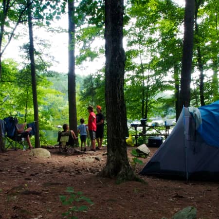 view of campsite 5 with children, blue tent and view of lake