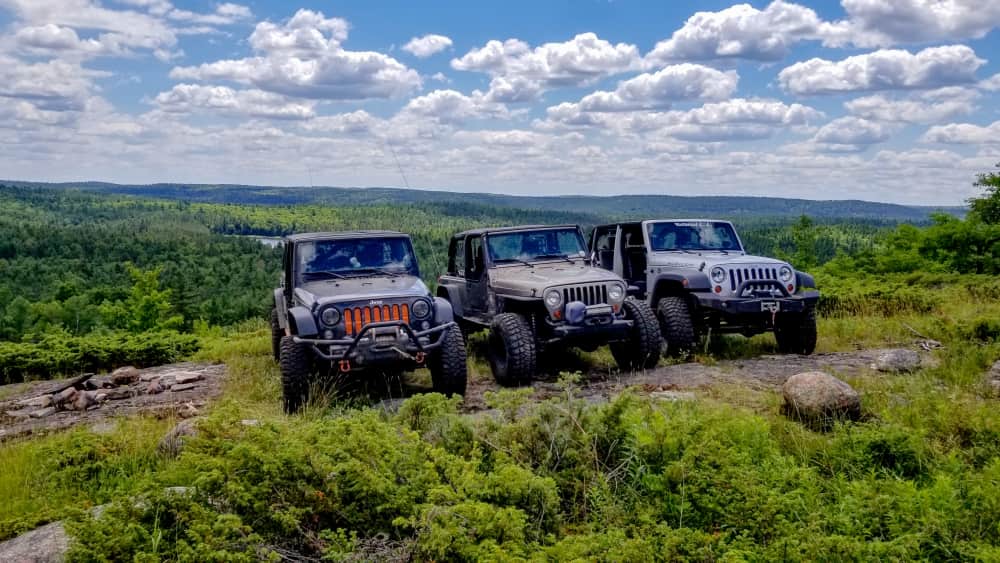 Three Jeeps lined up at top of Evergreen Mountain Trail with Longbay Lake in background