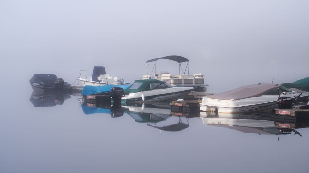 boats at the dock surrounded in fog