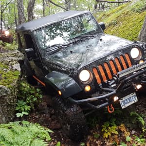 Jeep Rubicon offroad in the woods near black donald tent and trailer park