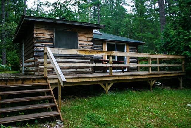 Front of Log Cabin on Norcan lake showing large deck with picnic table
