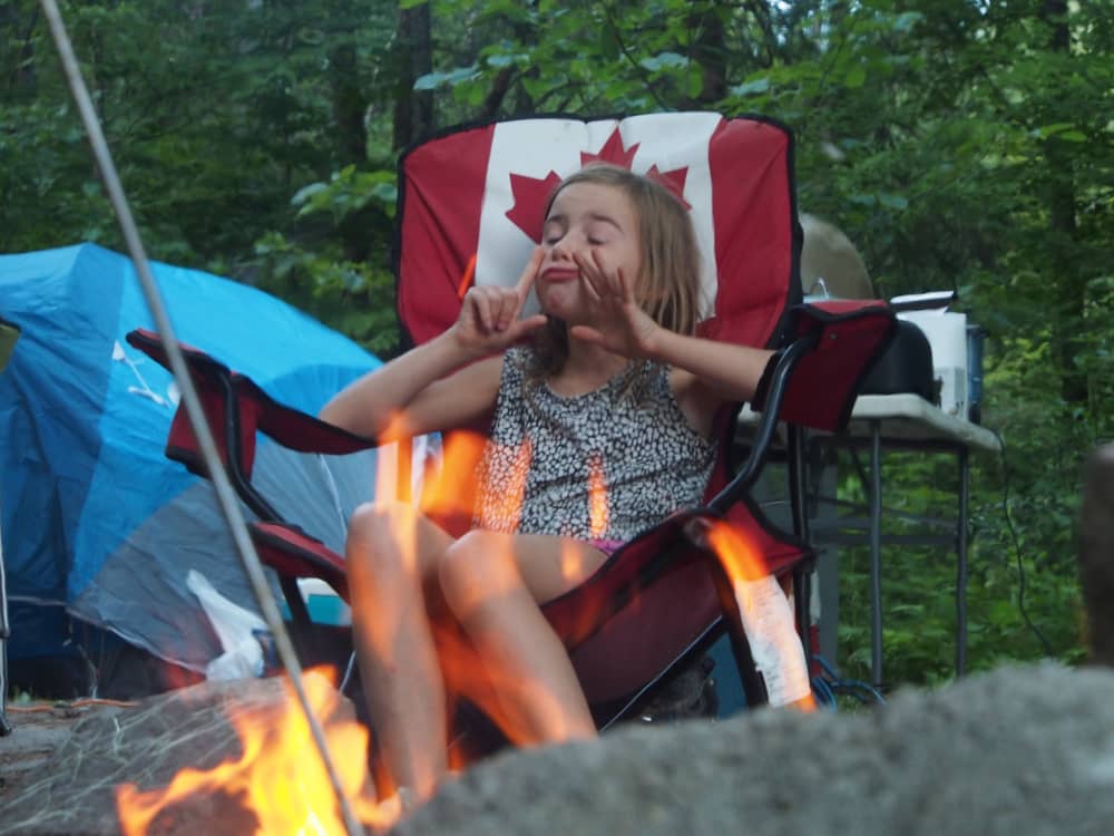 Little girl at campfire making a funny face